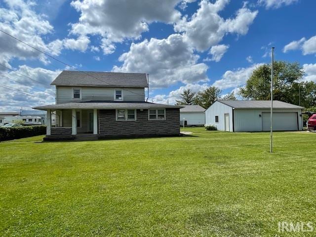1242 Edwin St, Huntington, IN 46750 - rear view of property with a detached garage, a lawn, a porch, stone siding, and an outbuilding