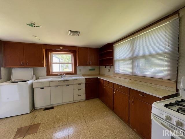 1242 Edwin St, Huntington, IN 46750 - kitchen featuring white range with gas stovetop, light countertops, light flooring, open shelves, and a sink