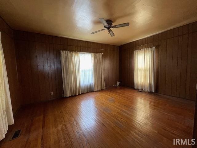 1242 Edwin St, Huntington, IN 46750 - spare room featuring ceiling fan, wood finished floors, and wooden walls