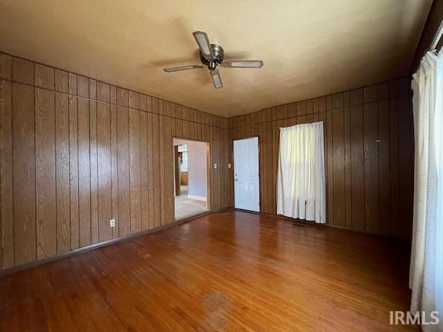 1242 Edwin St, Huntington, IN 46750 - unfurnished room with wood finished floors, ceiling fan, and wood walls