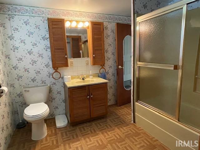 1242 Edwin St, Huntington, IN 46750 - bathroom featuring vanity, toilet, bath / shower combo with glass door, and wallpapered walls