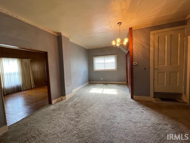 1242 Edwin St, Huntington, IN 46750 - empty room featuring a chandelier, carpet, ornamental molding, and baseboards