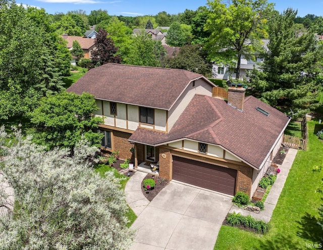 5318 Bedrock Ct, Fort Wayne, IN 46825 - view of front of home with driveway, stucco siding, a garage, a shingled roof, and a chimney