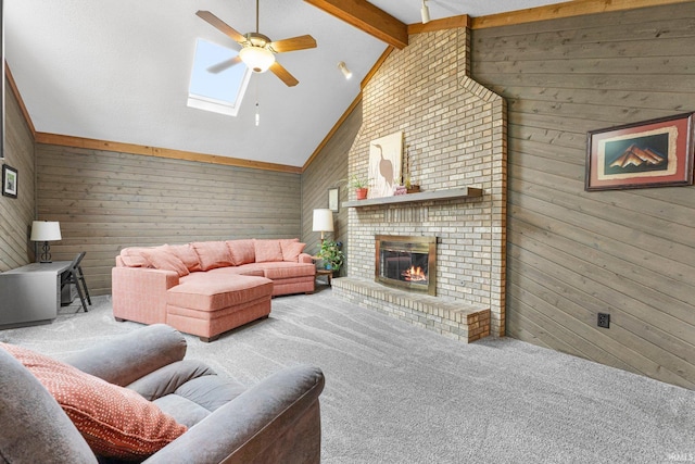 5318 Bedrock Ct, Fort Wayne, IN 46825 - carpeted living area featuring ceiling fan, wooden walls, a skylight, a brick fireplace, and beam ceiling