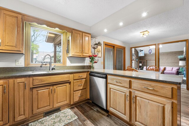 5318 Bedrock Ct, Fort Wayne, IN 46825 - kitchen featuring stainless steel dishwasher, a sink, a peninsula, a textured ceiling, and dark wood-style floors