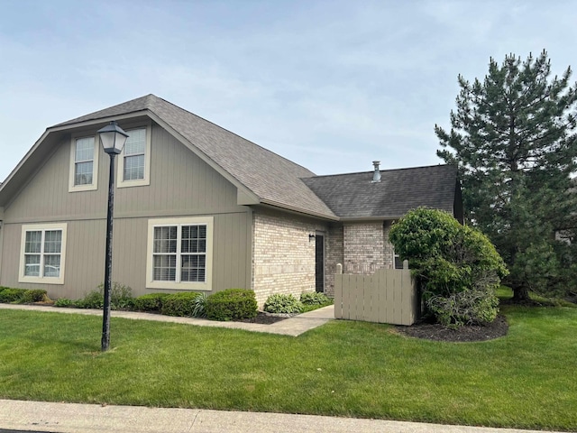 5242 Coventry Ln, Fort Wayne, IN 46804 - view of side of property featuring brick siding, a yard, and a shingled roof