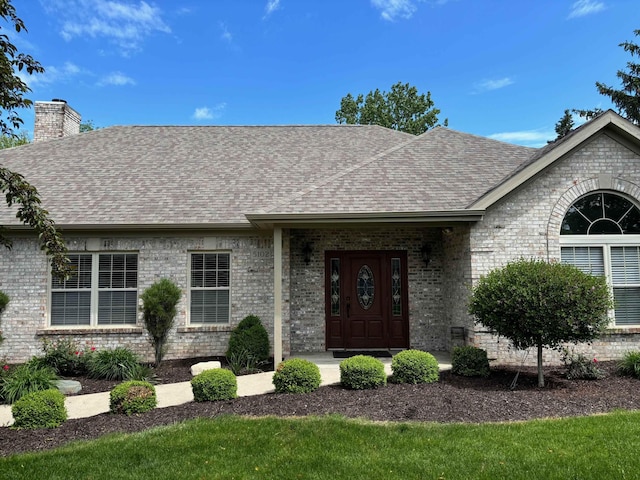 5242 Coventry Ln, Fort Wayne, IN 46804 - view of front of home with roof with shingles, a chimney, and brick siding