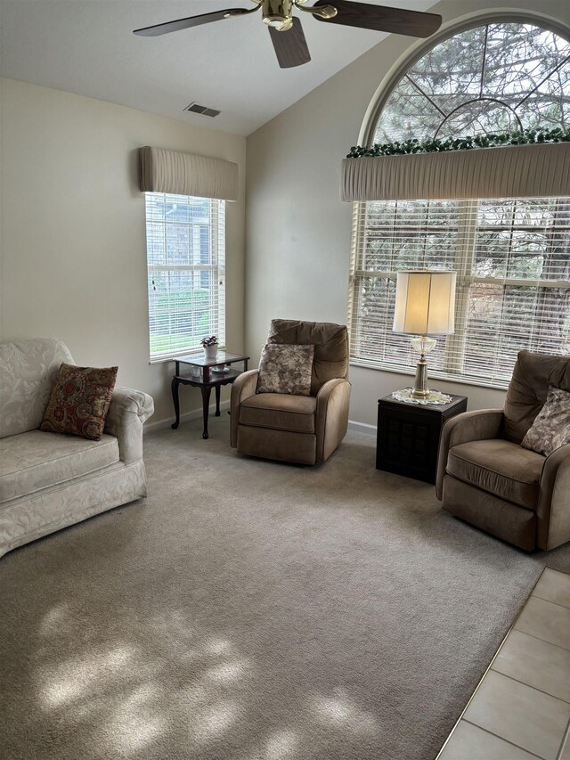 5242 Coventry Ln, Fort Wayne, IN 46804 - carpeted living room with ceiling fan, vaulted ceiling, baseboards, and tile patterned floors