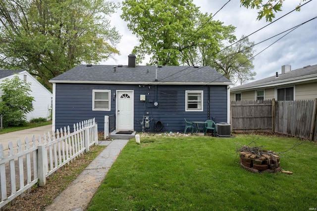 1122 Curdes Ave, Fort Wayne, IN 46805 - rear view of property featuring a fire pit, a chimney, central AC unit, and a shingled roof