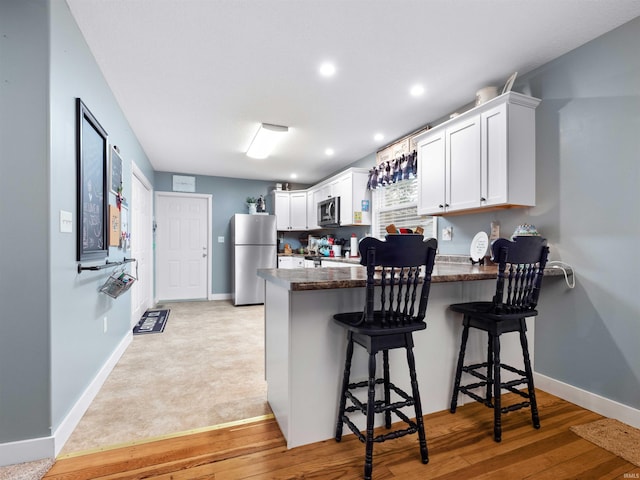 1346 Grayston Ave, Huntington, IN 46750 - kitchen featuring appliances with stainless steel finishes, a peninsula, baseboards, white cabinetry, and recessed lighting