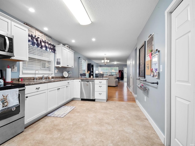 1346 Grayston Ave, Huntington, IN 46750 - kitchen featuring stainless steel appliances, open floor plan, a chandelier, a peninsula, and a sink