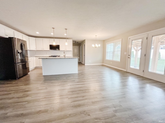 8115 Jt Ct, Evansville, IN 47715 - kitchen with appliances with stainless steel finishes, a chandelier, light wood finished floors, baseboards, and white cabinetry