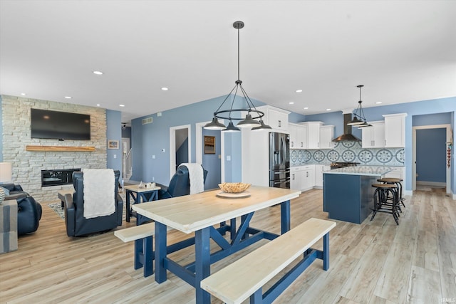 30860 Villa Dr, Granger, IN 46530 - dining area featuring light wood-type flooring, a stone fireplace, and recessed lighting