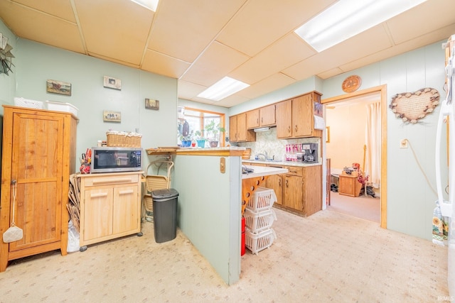 20 E Little St, Denver, IN 46926 - kitchen featuring stainless steel microwave, light countertops, light colored carpet, decorative backsplash, and a sink