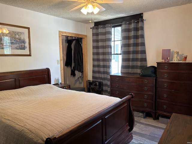 451 Miller Ave, Clarksville, IN 47129 - bedroom featuring wood finished floors, a textured ceiling, a closet, and a ceiling fan