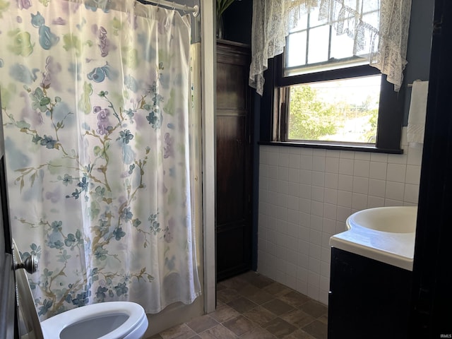 451 Miller Ave, Clarksville, IN 47129 - bathroom featuring vanity, tile walls, toilet, and shower / bath combo with shower curtain