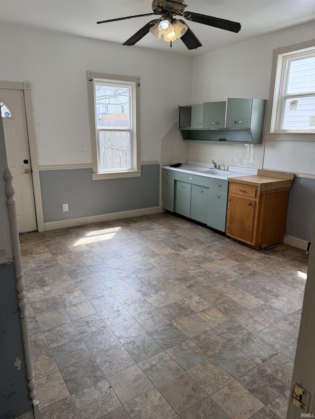2606 Pennsylvania St, Evansville, IN 47712 - kitchen featuring stone finish flooring, ceiling fan, decorative backsplash, and baseboards