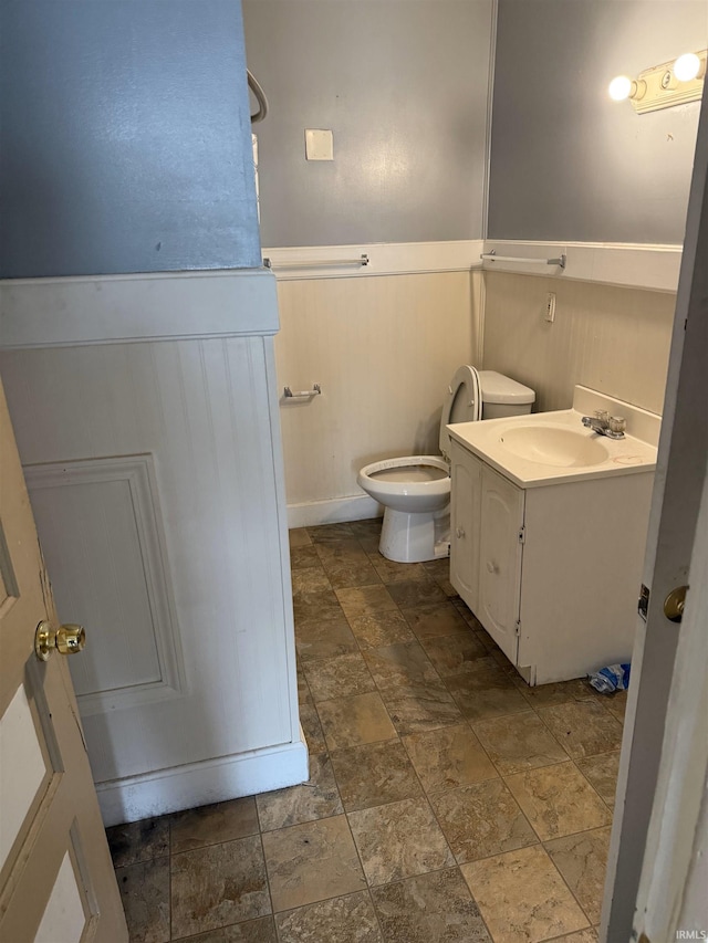 2606 Pennsylvania St, Evansville, IN 47712 - bathroom with vanity, stone finish flooring, toilet, and wainscoting