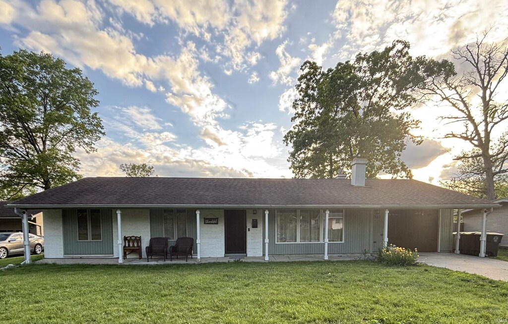 2923 Inwood Dr, Fort Wayne, IN 46815 - view of front of home with a porch, an attached garage, a front yard, a chimney, and concrete driveway