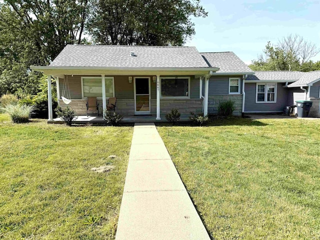 6447 W Delap Rd, Ellettsville, IN 47429 - view of front facade with a porch, a front lawn, a shingled roof, and stone siding