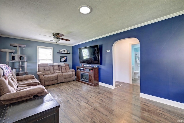 6447 W Delap Rd, Ellettsville, IN 47429 - living area featuring arched walkways, a textured ceiling, ceiling fan, ornamental molding, and baseboards