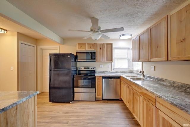 6447 W Delap Rd, Ellettsville, IN 47429 - kitchen featuring stainless steel appliances, a sink, light brown cabinets, light wood-type flooring, and a textured ceiling