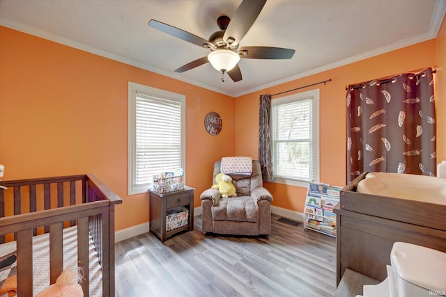 6447 W Delap Rd, Ellettsville, IN 47429 - bedroom with light wood-style flooring, baseboards, a nursery area, and crown molding