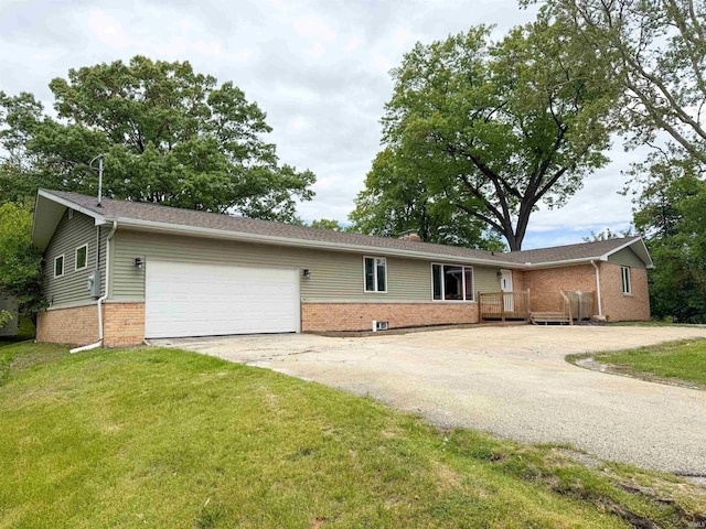22073 County Road 10 W, Elkhart, IN 46514 - ranch-style house with brick siding, asphalt driveway, a garage, and a front yard