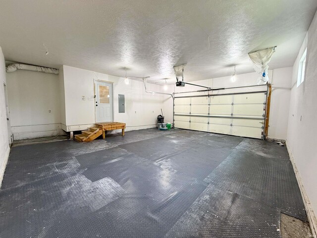 22073 County Road 10 W, Elkhart, IN 46514 - garage featuring electric panel, a garage door opener, and baseboards