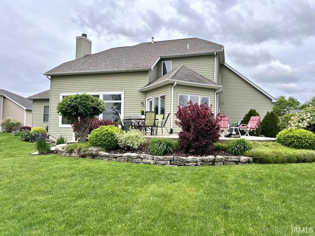 1442 Centerbrook Dr, New Haven, IN 46774 - back of house featuring a patio area, a chimney, a lawn, and a shingled roof
