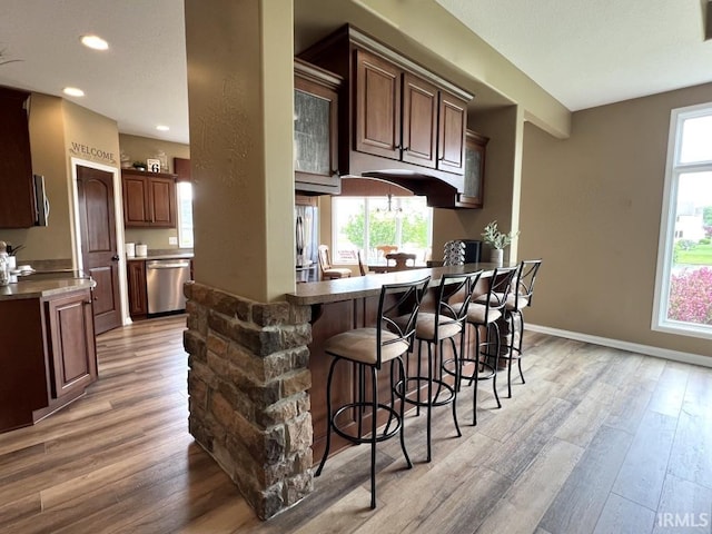 1442 Centerbrook Dr, New Haven, IN 46774 - kitchen with appliances with stainless steel finishes, light wood-type flooring, a breakfast bar, recessed lighting, and a peninsula