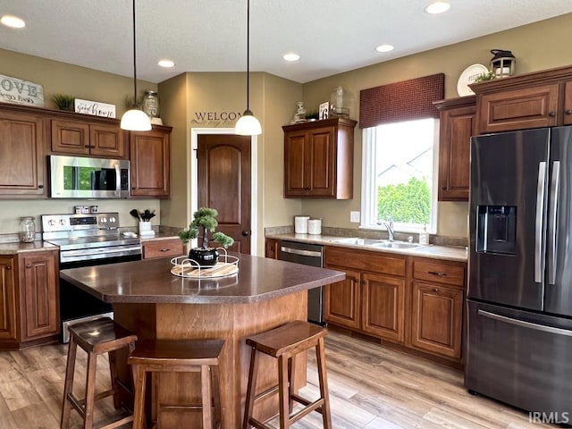1442 Centerbrook Dr, New Haven, IN 46774 - kitchen with appliances with stainless steel finishes, a sink, a kitchen breakfast bar, light wood-style flooring, and recessed lighting