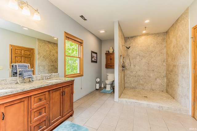 501 W Fox Lake Rd, Angola, IN 46730 - bathroom with a tile shower, double vanity, toilet, tile patterned flooring, and recessed lighting