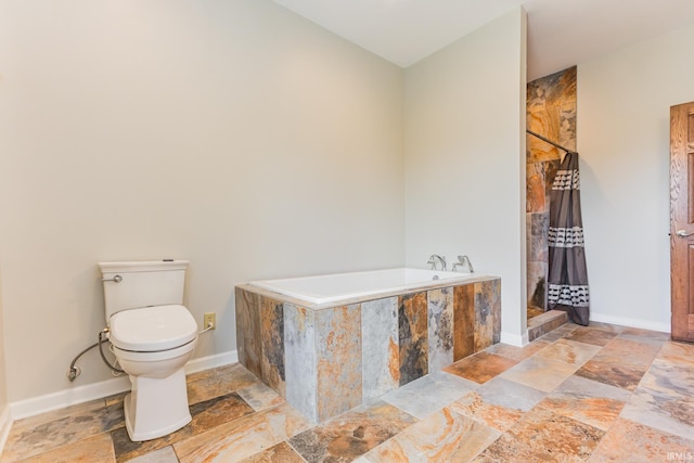 501 W Fox Lake Rd, Angola, IN 46730 - bathroom featuring stone tile floors, tiled shower, toilet, a garden tub, and baseboards