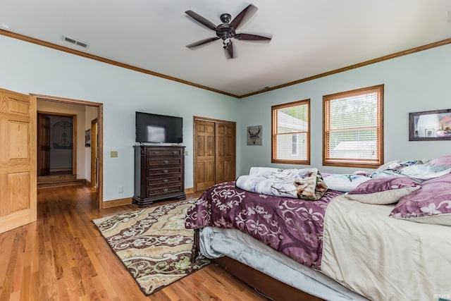 501 W Fox Lake Rd, Angola, IN 46730 - bedroom with ornamental molding, wood finished floors, a closet, a ceiling fan, and baseboards