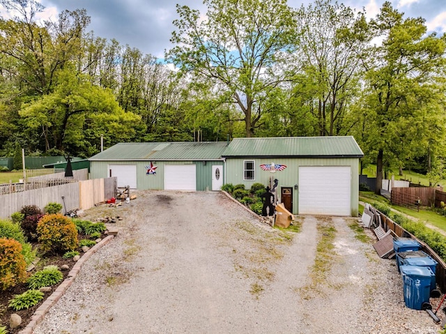 501 W Fox Lake Rd, Angola, IN 46730 - ranch-style home with dirt driveway, metal roof, view of wooded area, and an outbuilding