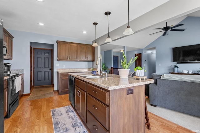 612 E Dunn Rd, New Carlisle, IN 46552 - kitchen featuring black appliances, open floor plan, a sink, light wood-type flooring, and a kitchen breakfast bar