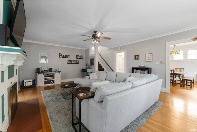 2215 Kensington Blvd, Fort Wayne, IN 46805 - living area featuring stairs, light wood-style flooring, a ceiling fan, crown molding, and baseboards