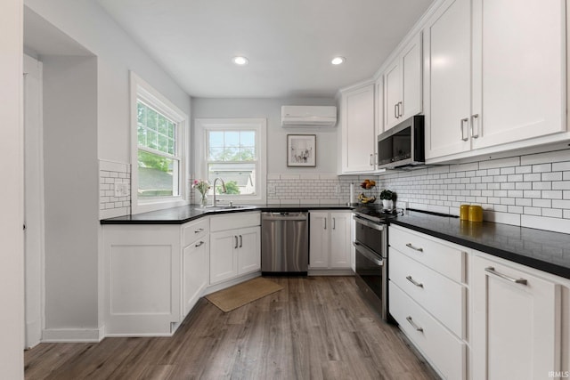 2215 Kensington Blvd, Fort Wayne, IN 46805 - kitchen with stainless steel appliances, a wall unit AC, a sink, dark countertops, and recessed lighting