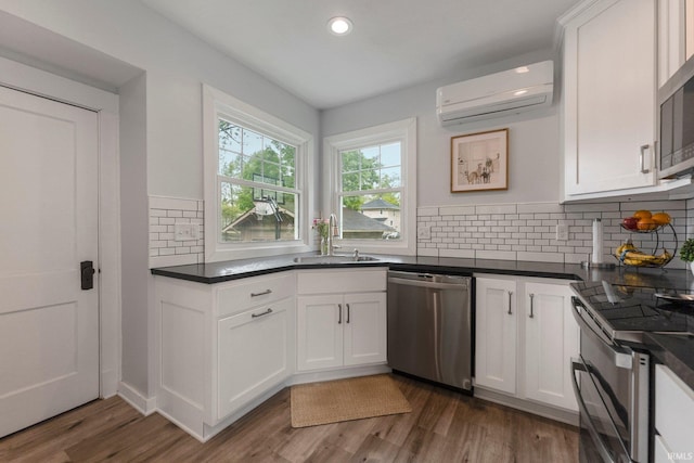 2215 Kensington Blvd, Fort Wayne, IN 46805 - kitchen with appliances with stainless steel finishes, a sink, an AC wall unit, dark countertops, and recessed lighting