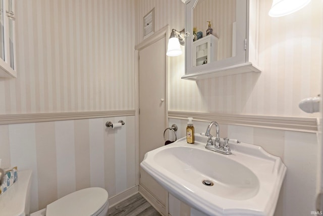 2215 Kensington Blvd, Fort Wayne, IN 46805 - half bath with wallpapered walls, toilet, a sink, and wood finished floors