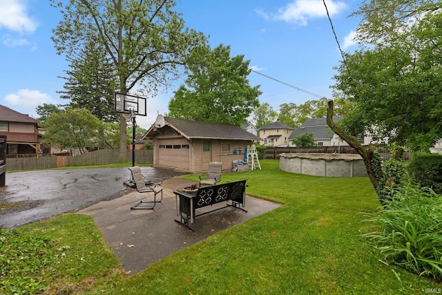 2215 Kensington Blvd, Fort Wayne, IN 46805 - view of yard featuring an outdoor structure, a detached garage, and an outdoor fire pit