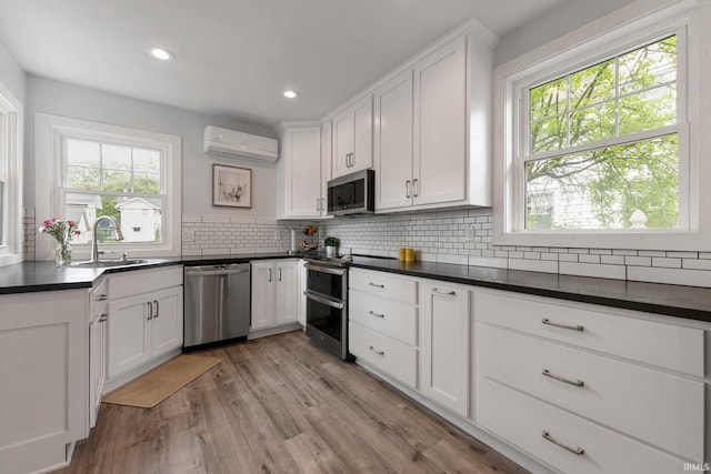 2215 Kensington Blvd, Fort Wayne, IN 46805 - kitchen featuring appliances with stainless steel finishes, a wall mounted AC, a sink, dark countertops, and recessed lighting