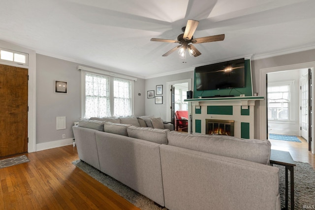 2215 Kensington Blvd, Fort Wayne, IN 46805 - living room with ornamental molding, a glass covered fireplace, wood finished floors, baseboards, and a ceiling fan