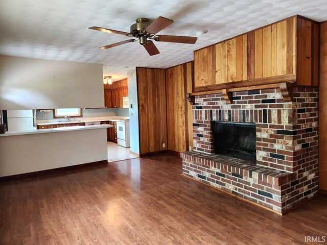 2790 E Cherry Ln, Marion, IN 46953 - unfurnished living room with a ceiling fan, a sink, wood finished floors, and a brick fireplace