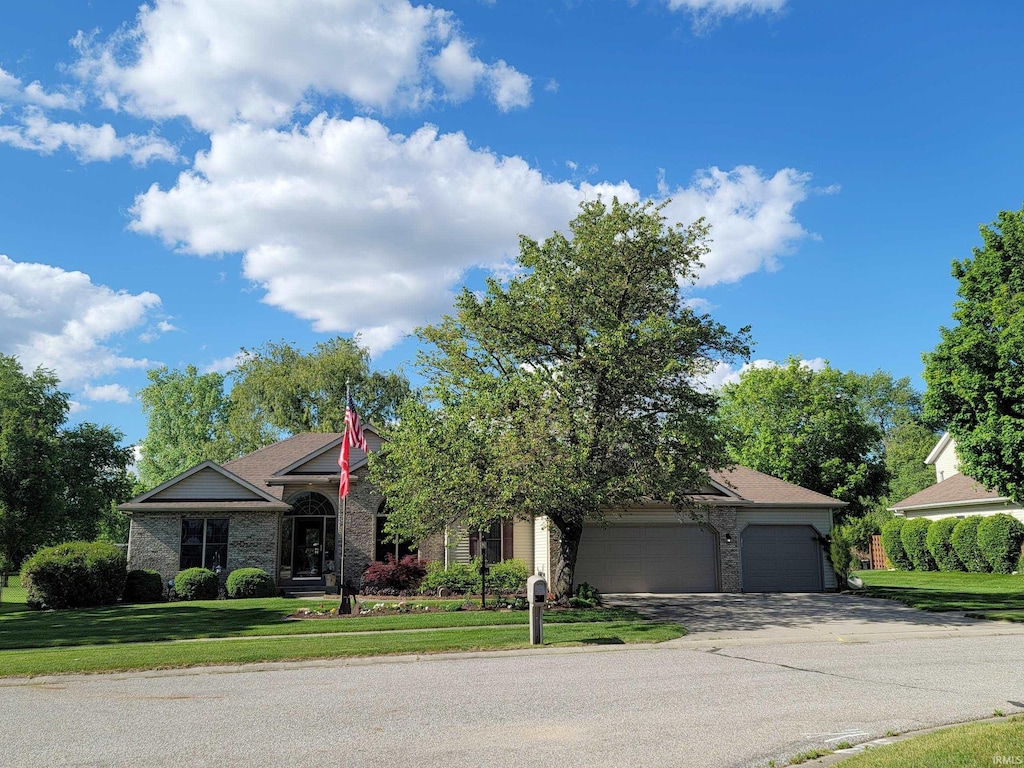 18961 Wilson Dr, Goshen, IN 46528 - view of front facade featuring an attached garage, a front yard, brick siding, and asphalt driveway