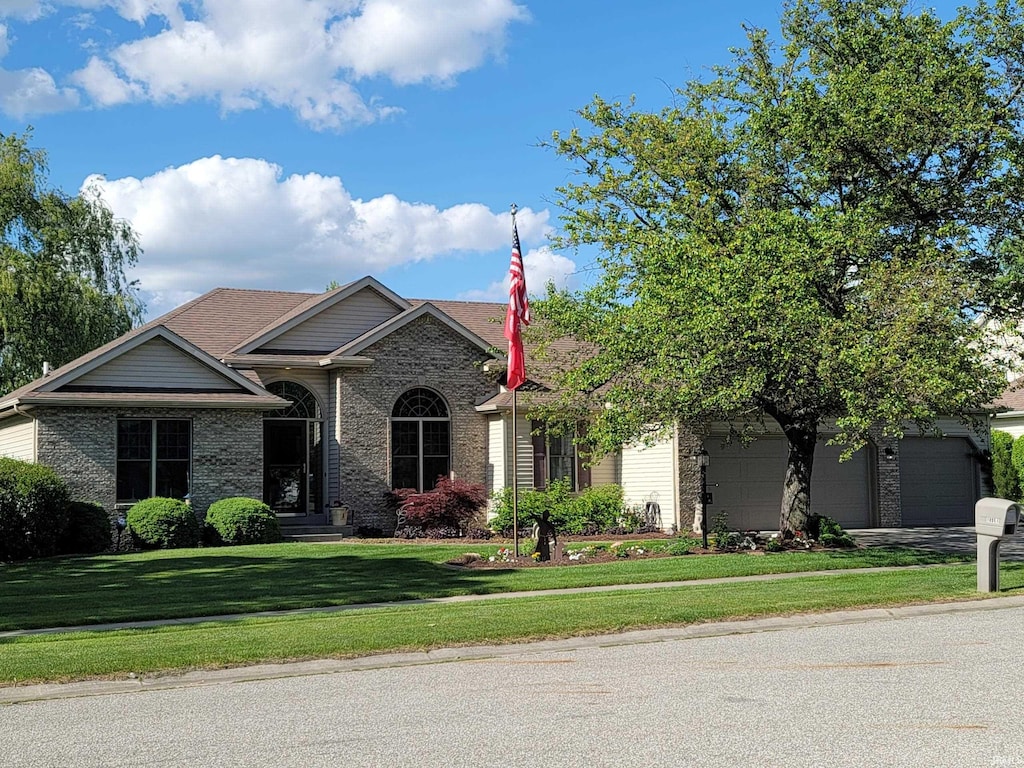 18961 Wilson Dr, Goshen, IN 46528 - view of front of property with a front yard, brick siding, driveway, and a garage