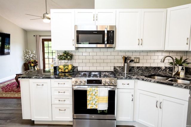 3850 W Woodmere Ct, Bloomington, IN 47403 - kitchen with appliances with stainless steel finishes, a sink, backsplash, white cabinets, and dark stone countertops