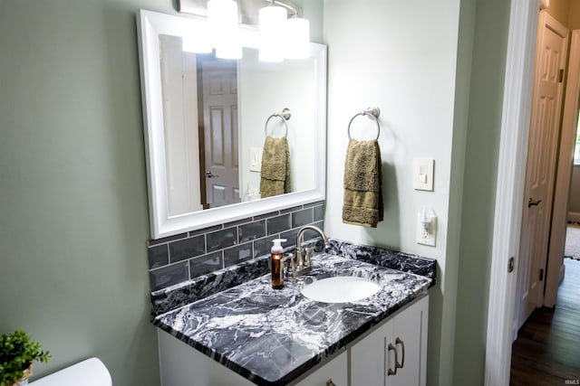 3850 W Woodmere Ct, Bloomington, IN 47403 - bathroom with vanity, toilet, tasteful backsplash, and wood finished floors