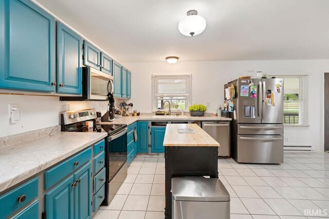 6659 W 400 S, Swayzee, IN 46986 - kitchen with appliances with stainless steel finishes, a baseboard radiator, a sink, light tile patterned flooring, and wooden counters